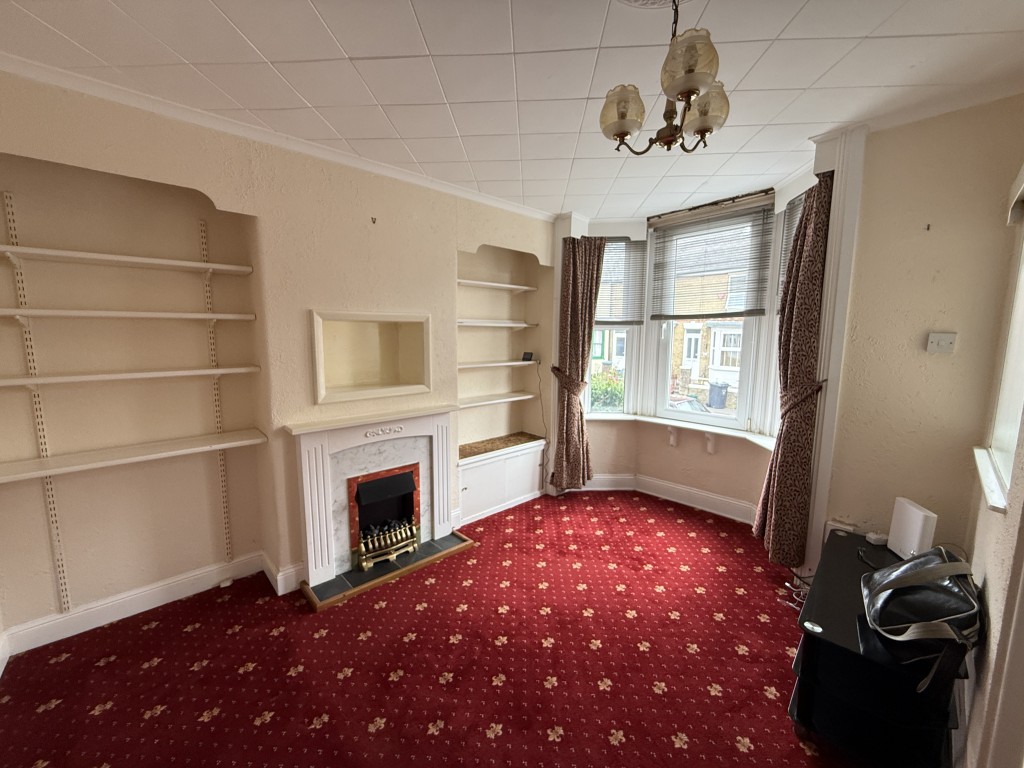 Lot: 142 - FREEHOLD TWO-BEDROOM HOUSE IN NEED OF IMPROVEMENT - Living room with carpet and fireplace